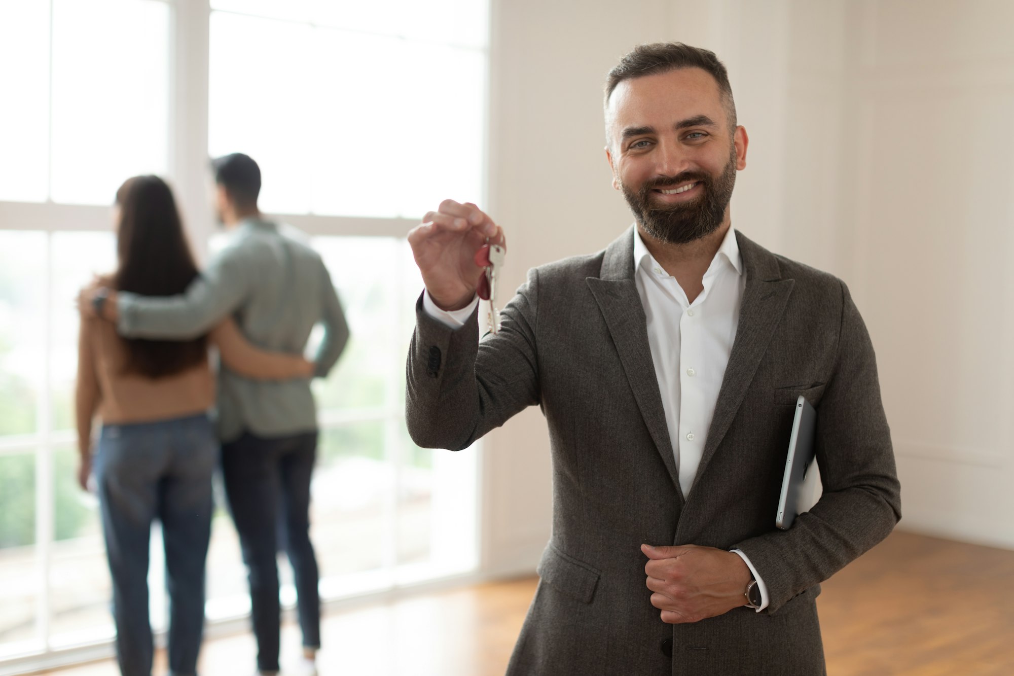 Portrait Of Smiling Real Estate Agent Holding And Showing Key